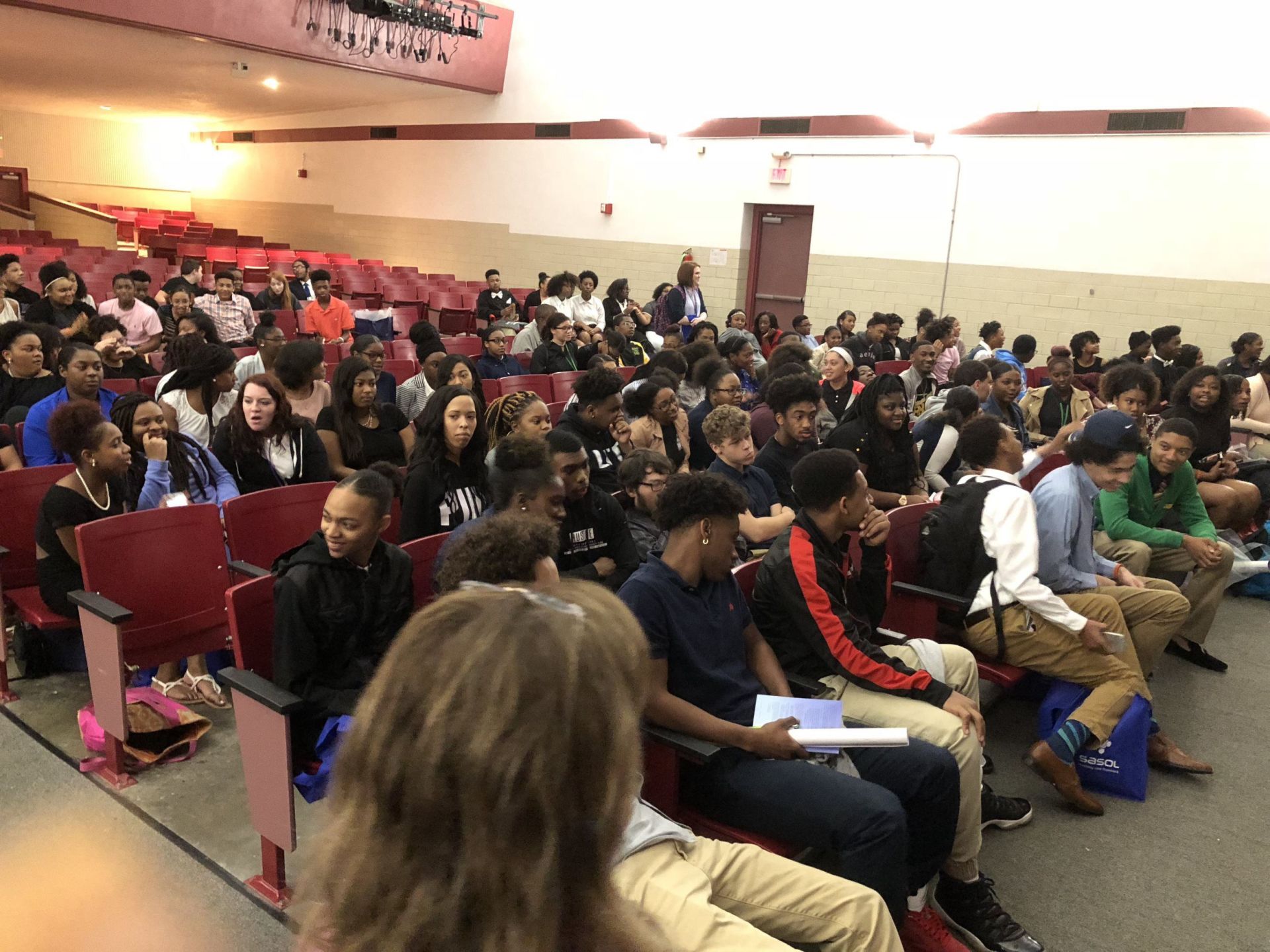 A large group of people are sitting in an auditorium.