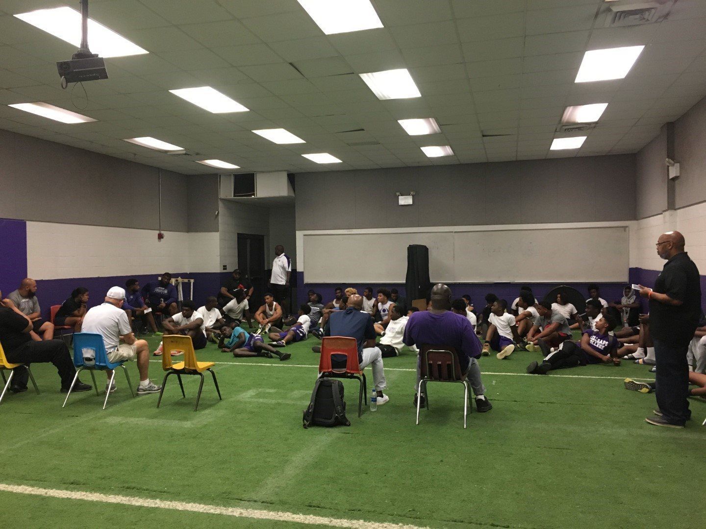 A group of people are sitting in chairs in a large room.
