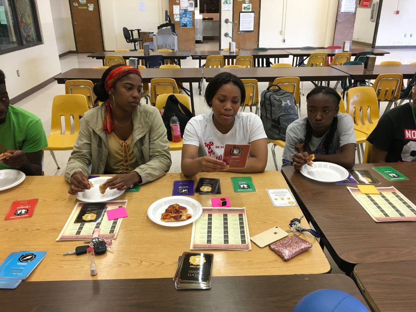 A group of people are sitting at a table eating pizza.