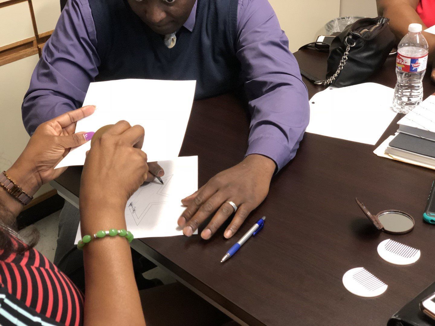 A man and a woman are sitting at a table looking at papers