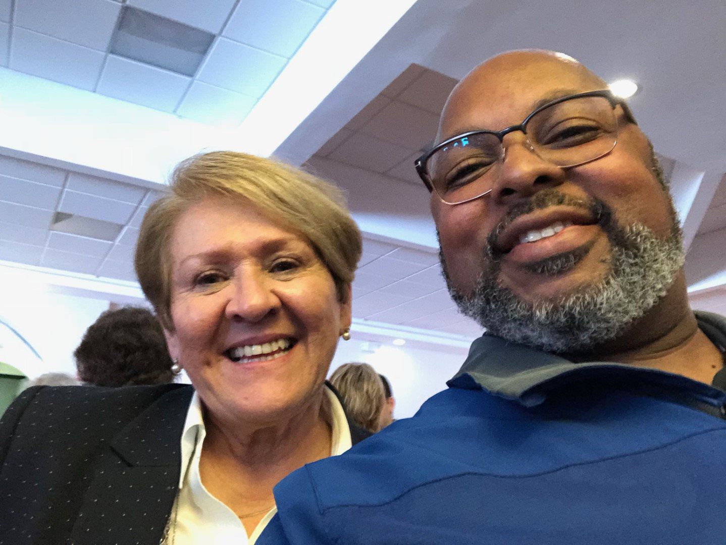 A man and a woman are posing for a picture and smiling for the camera.