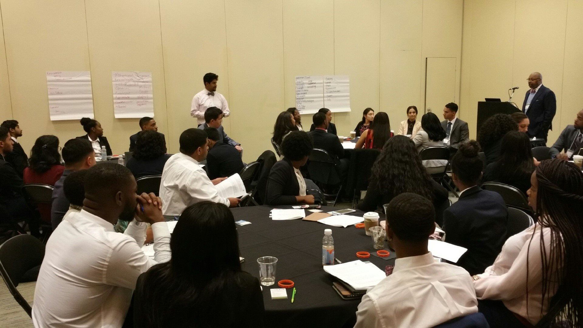 A group of people are sitting around a table in a conference room.