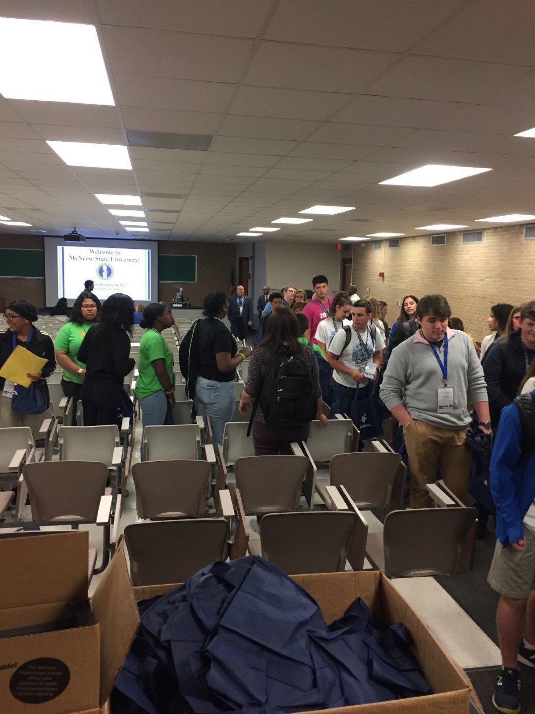 A large group of people are gathered in a classroom.