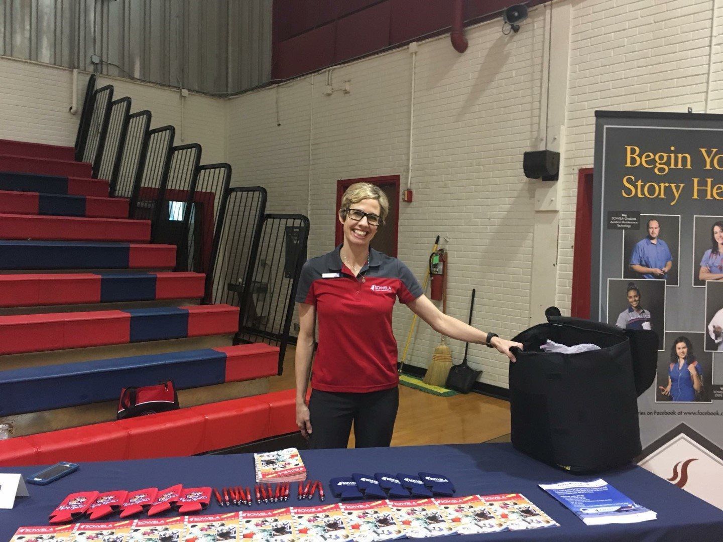 A woman is standing in front of a table in a gym.