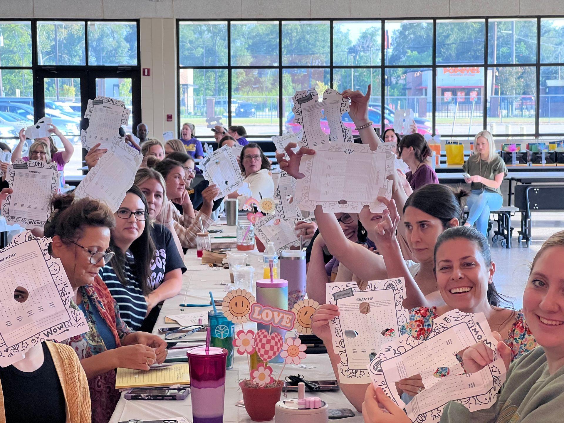 A group of people are sitting at a table holding pieces of paper.