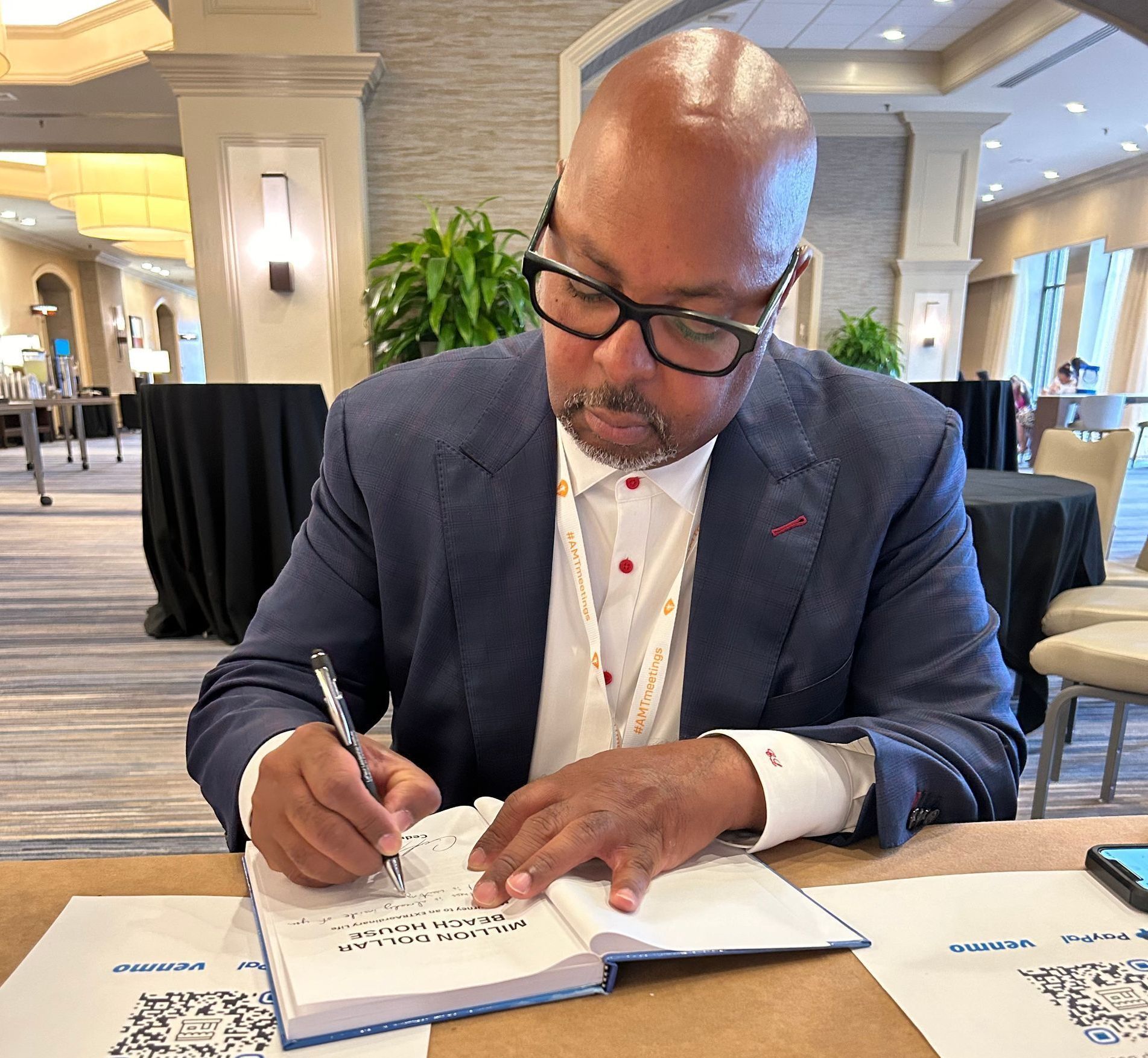 A man in a suit is writing in a notebook