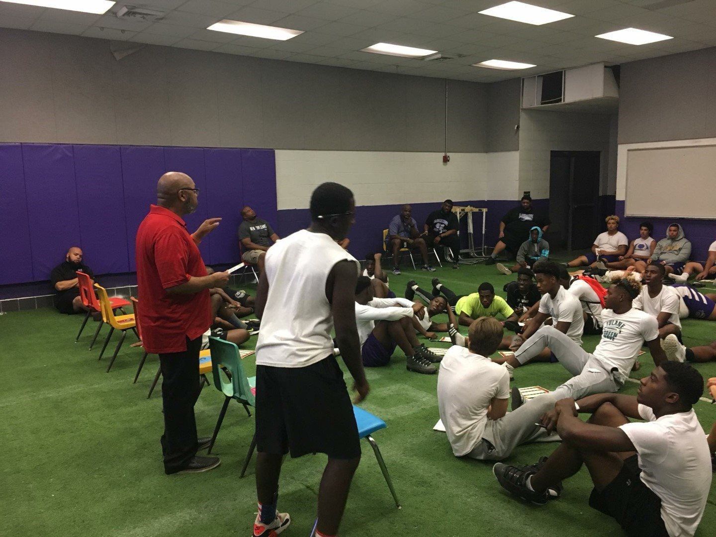 A group of young men are doing sit ups in a gym