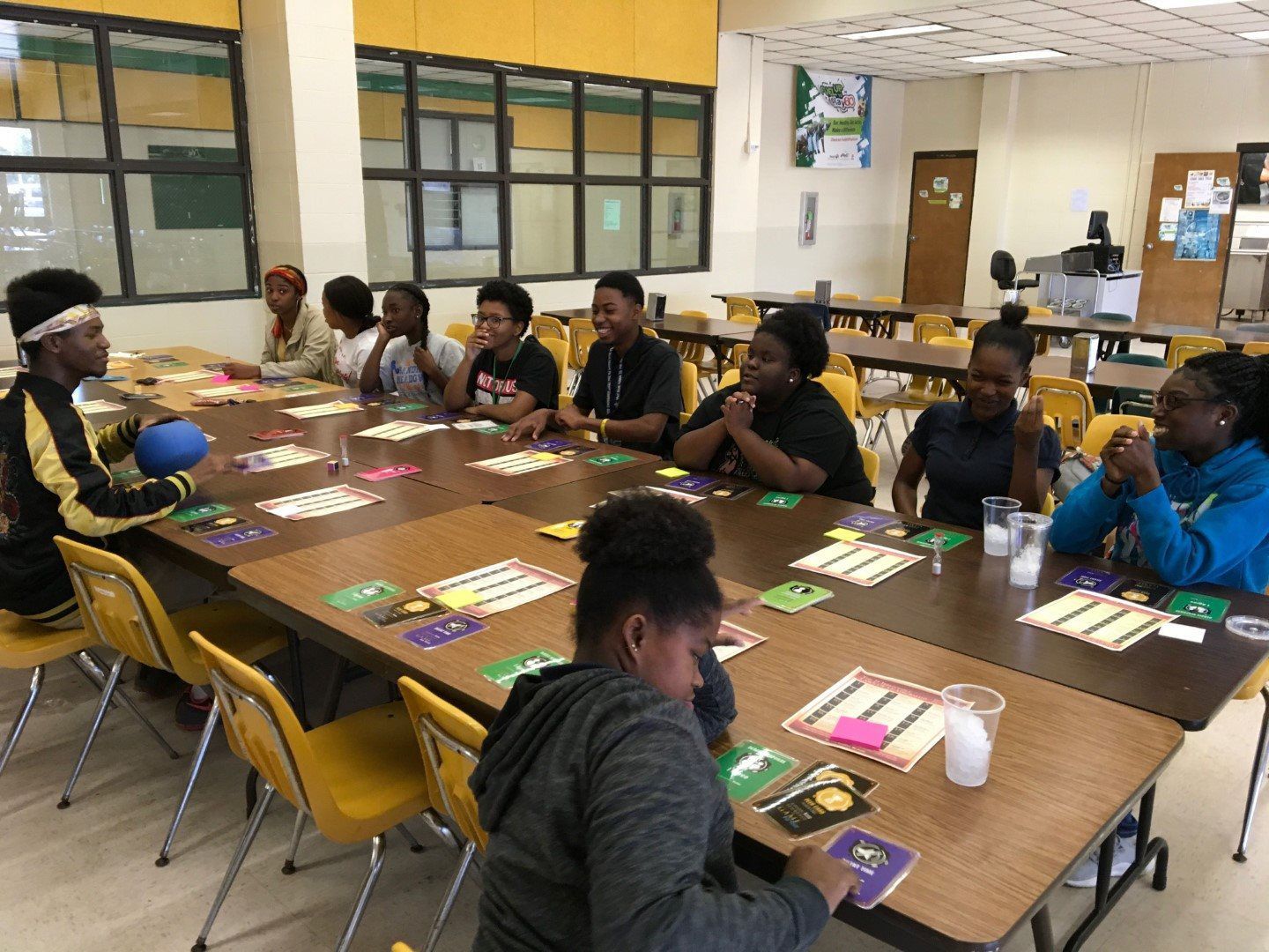 A group of people are sitting at tables in a room playing a game.