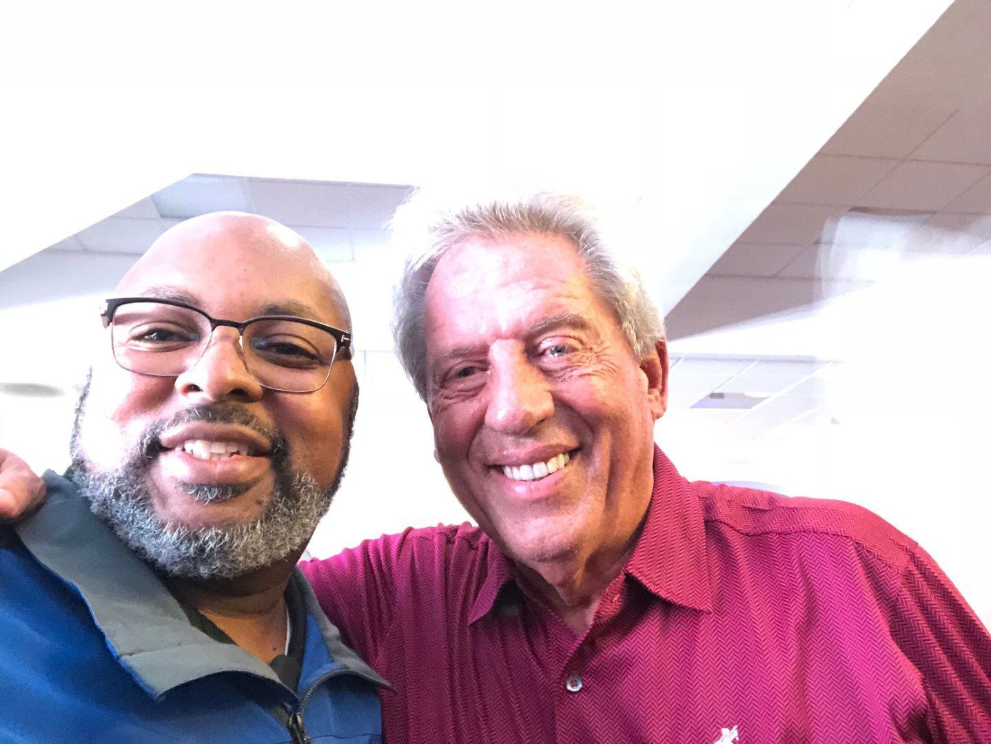 Two men are posing for a picture together and smiling for the camera.