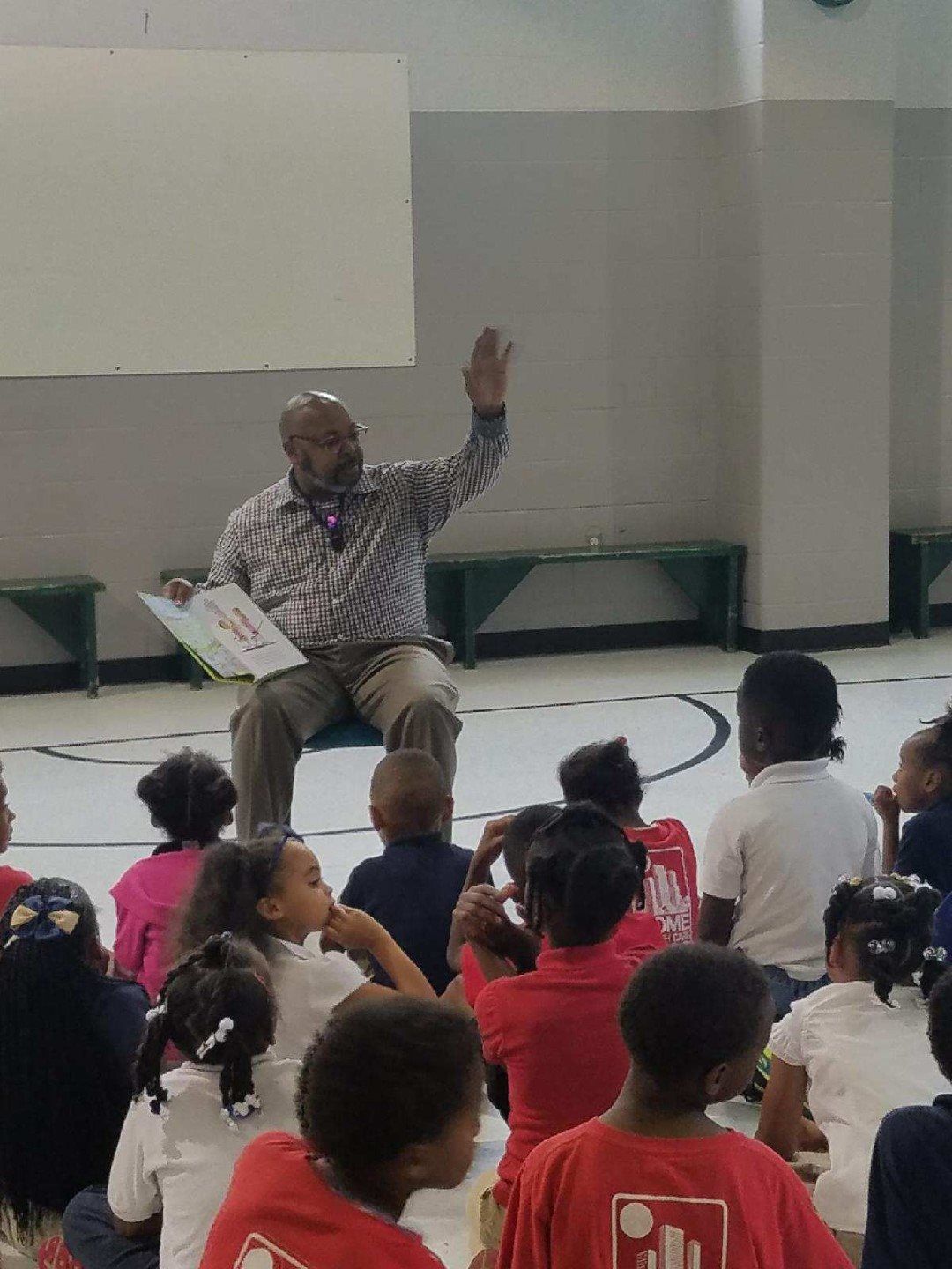 A man is reading a book to a group of children