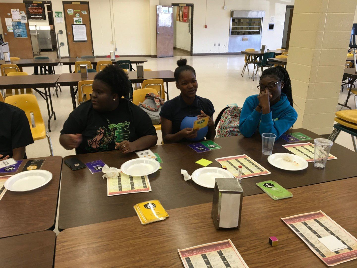 A group of people are sitting at a table with plates and napkins.