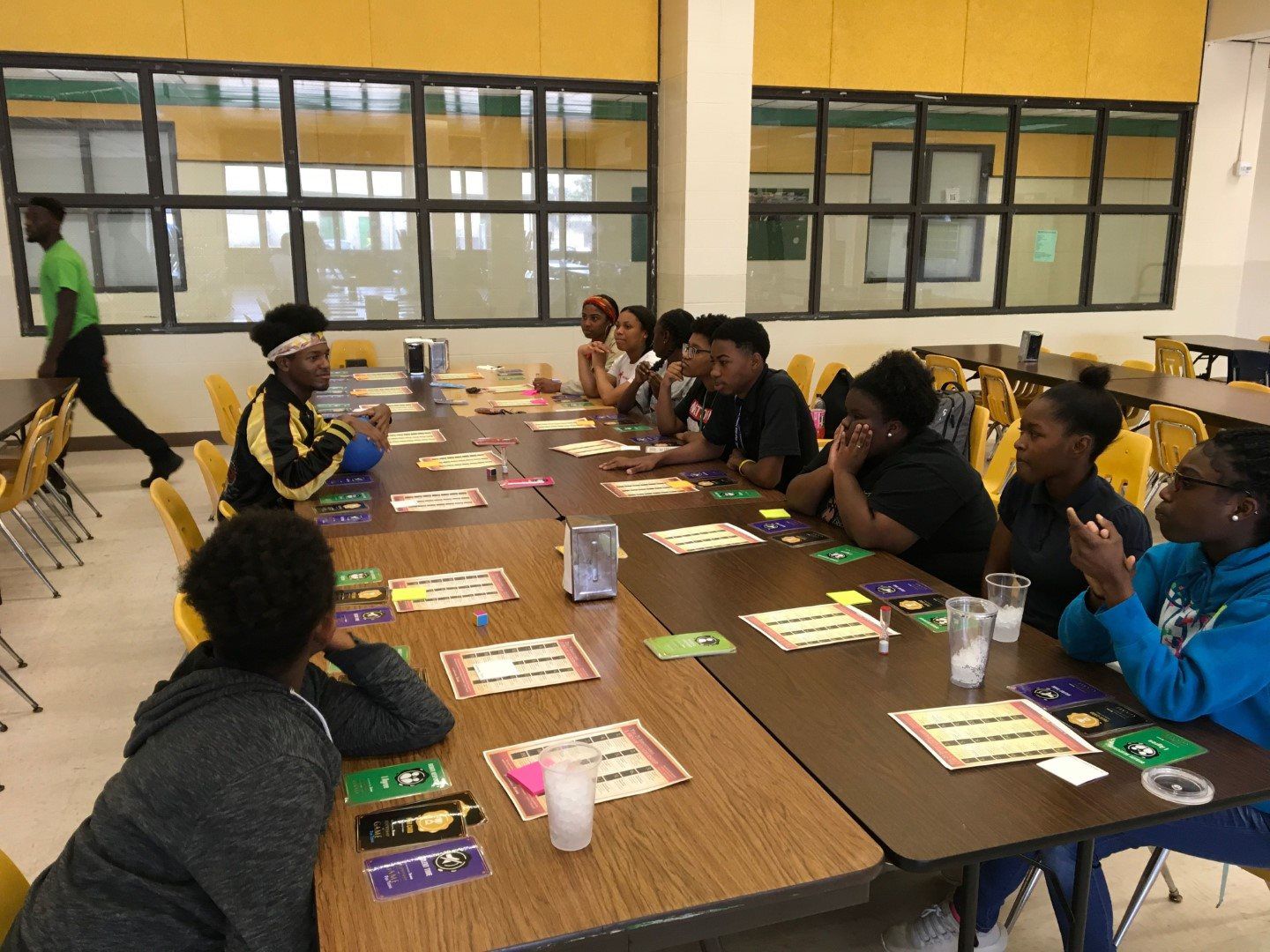 A group of people are sitting at tables in a cafeteria