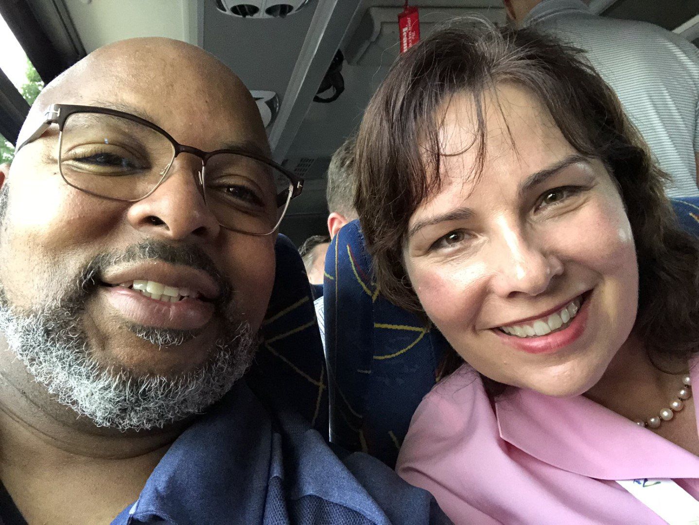 A man and a woman are posing for a picture on a bus