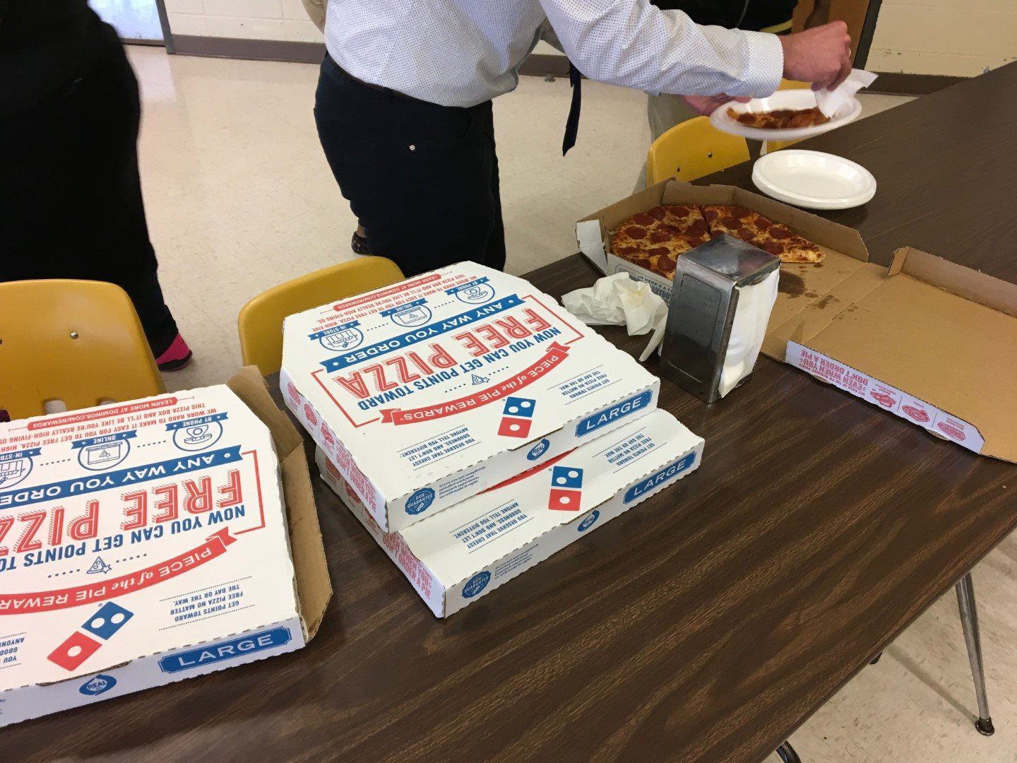 A man is taking a domino 's pizza from a table