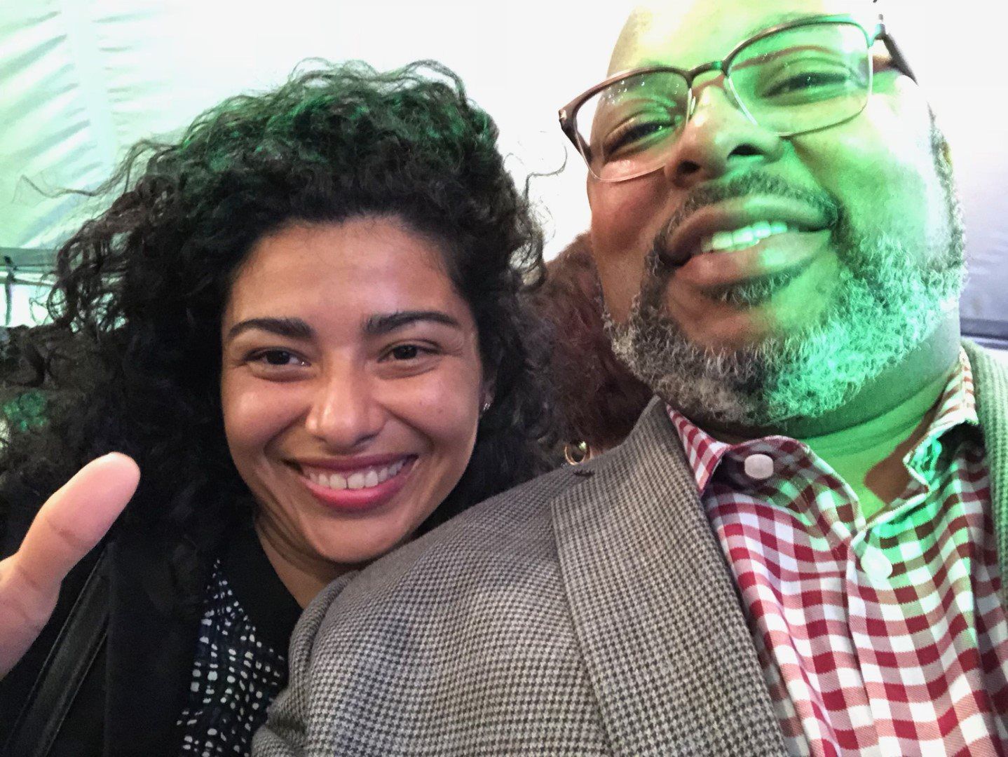 A man and a woman are posing for a picture and the woman is smiling