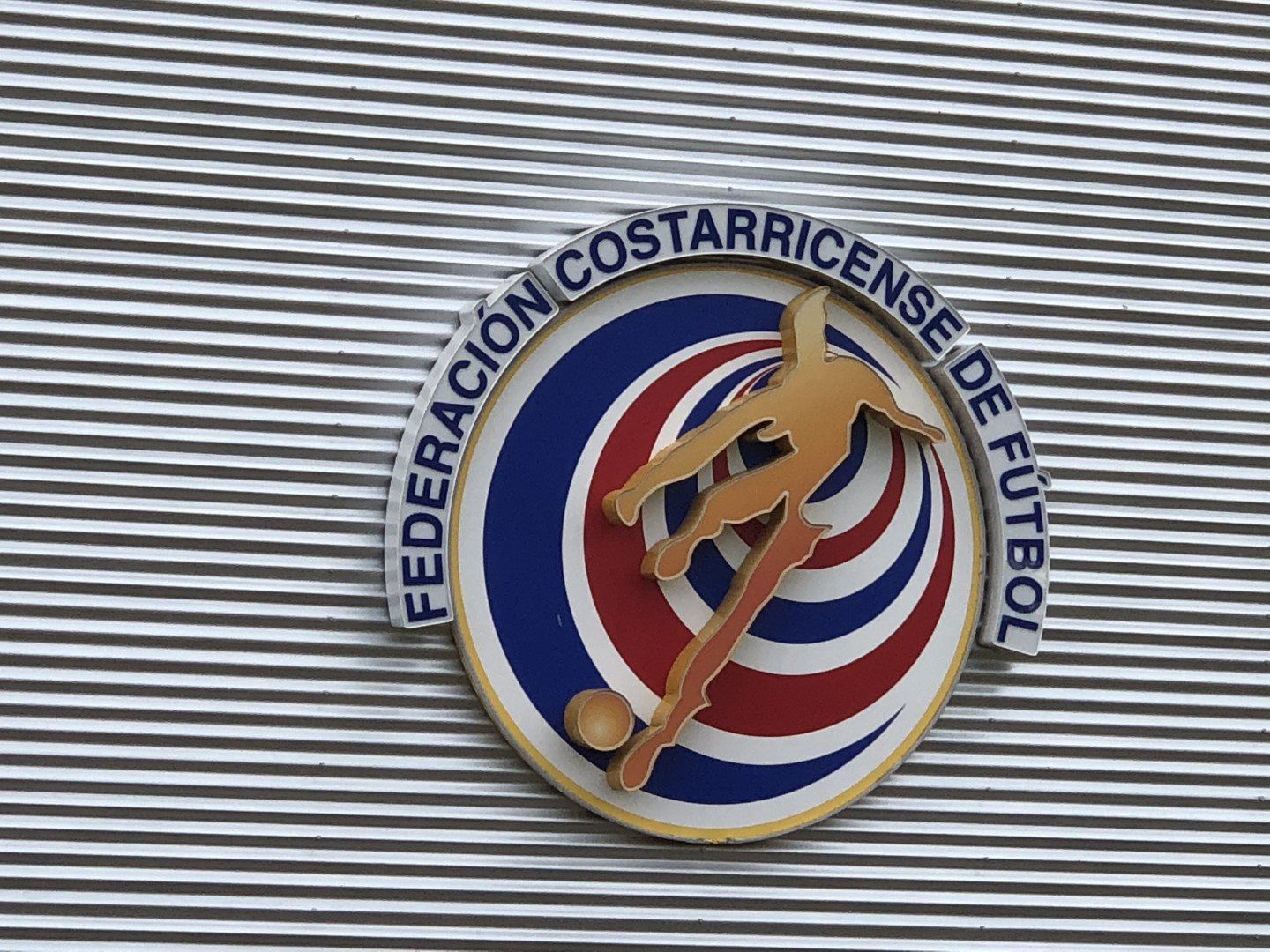 The logo for federacion costarricense de futbol is on the side of a building