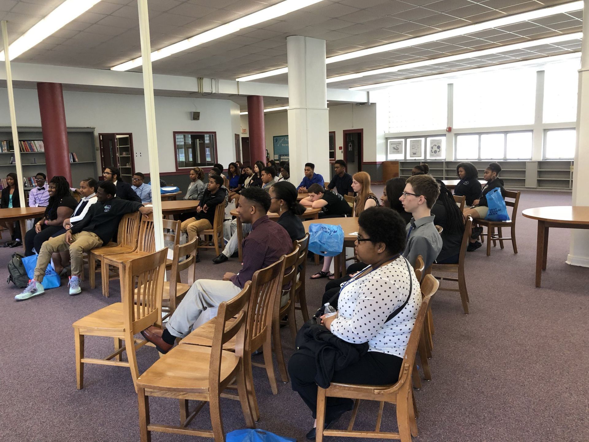 A group of people are sitting in chairs in a large room.