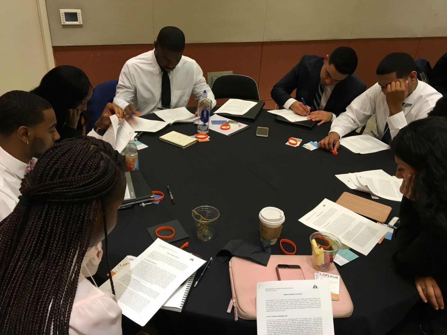 A group of people are sitting around a table with papers on it