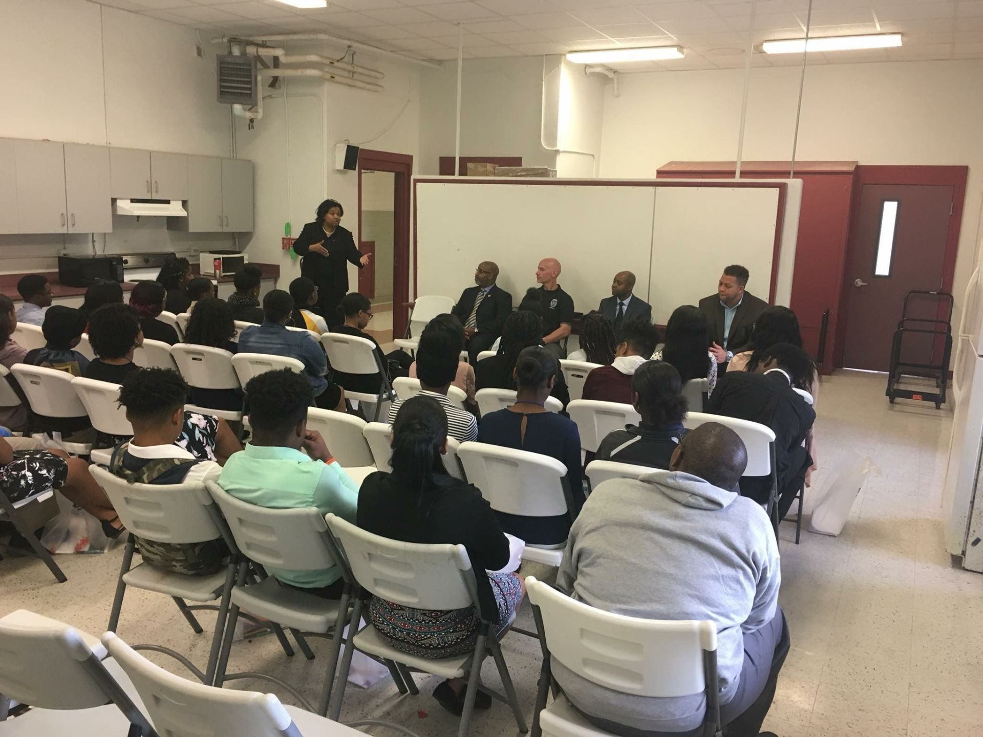 A group of people are sitting in chairs in a room.