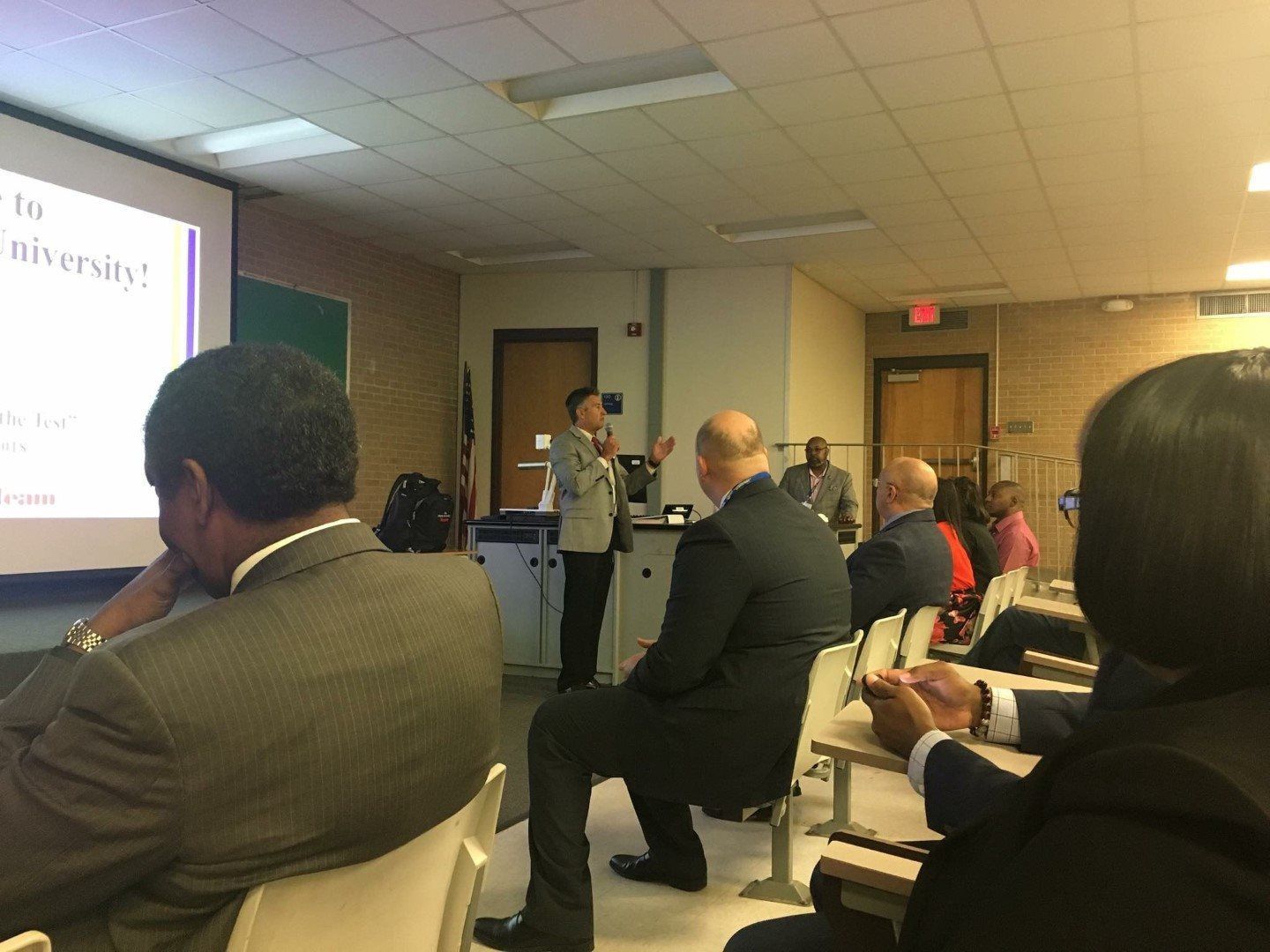 A woman is giving a presentation to a group of people in a lecture hall.
