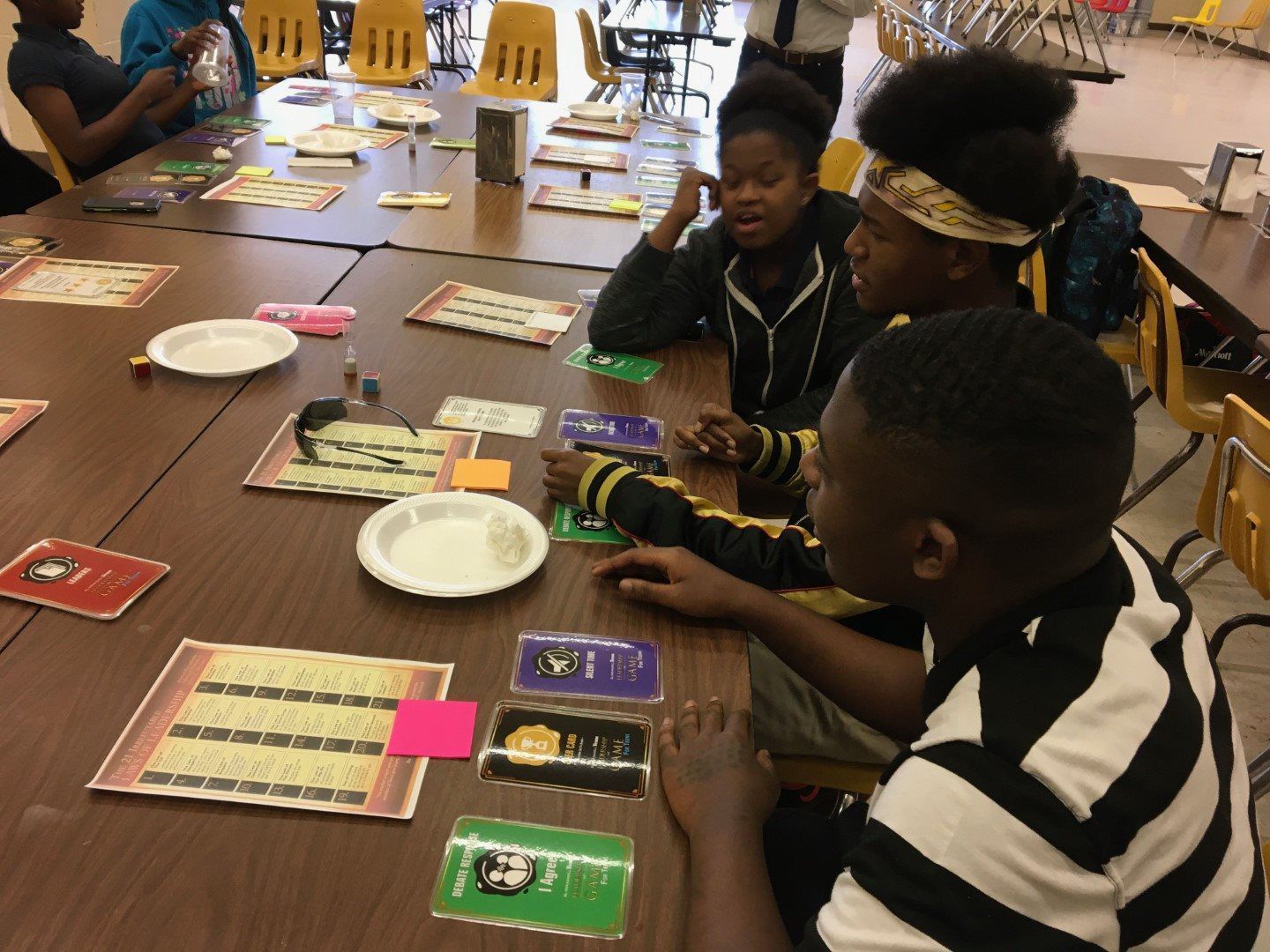 A group of children are sitting at a table playing a game