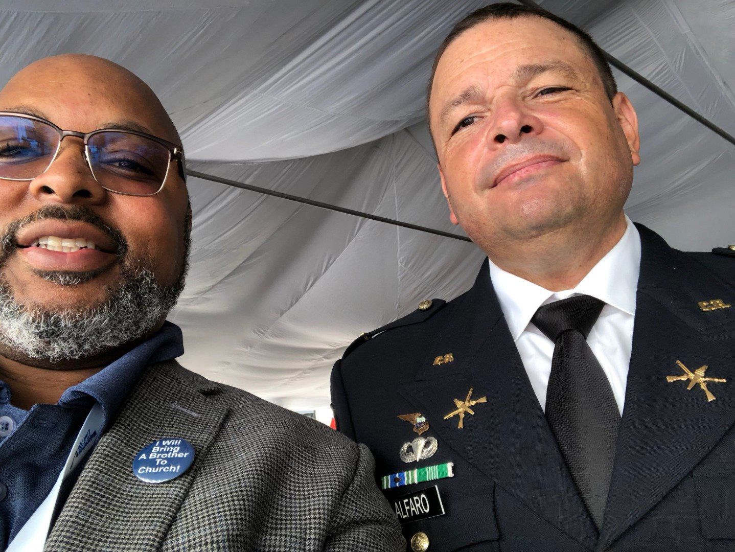 Two men in military uniforms are posing for a picture