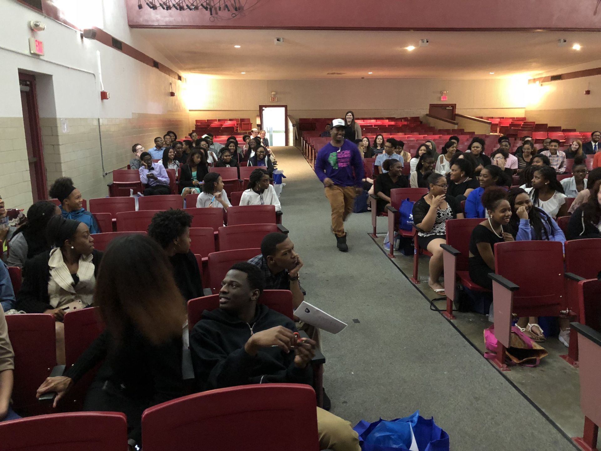 A group of people are sitting in a large auditorium.