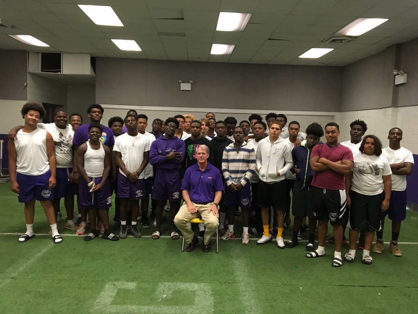A group of people are posing for a picture in a gym.
