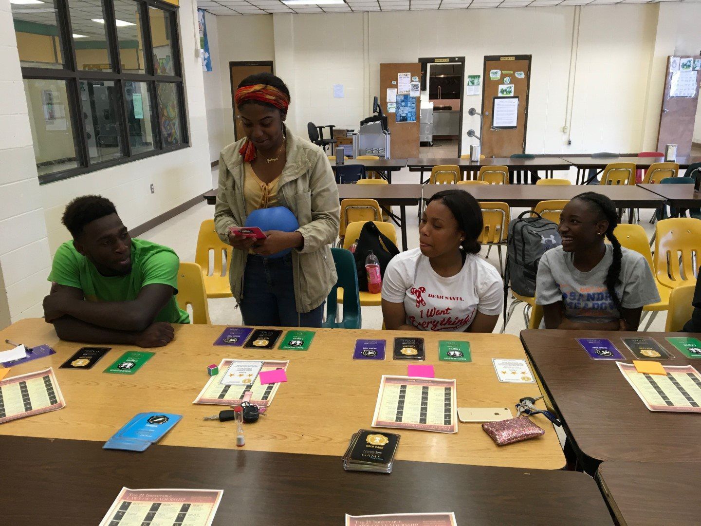 A group of people are sitting around a table in a classroom