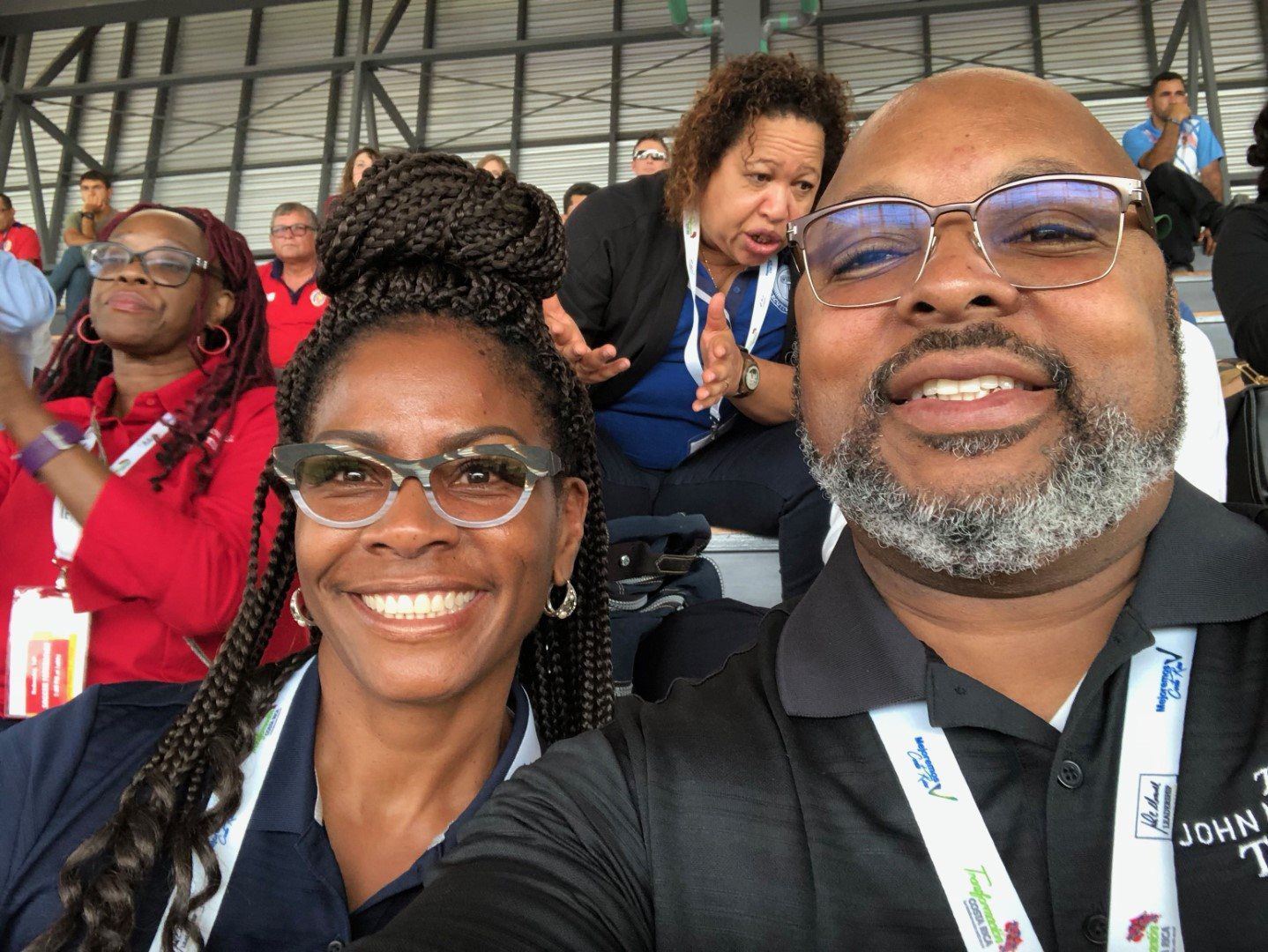 A man and a woman are posing for a picture while sitting in a stadium.