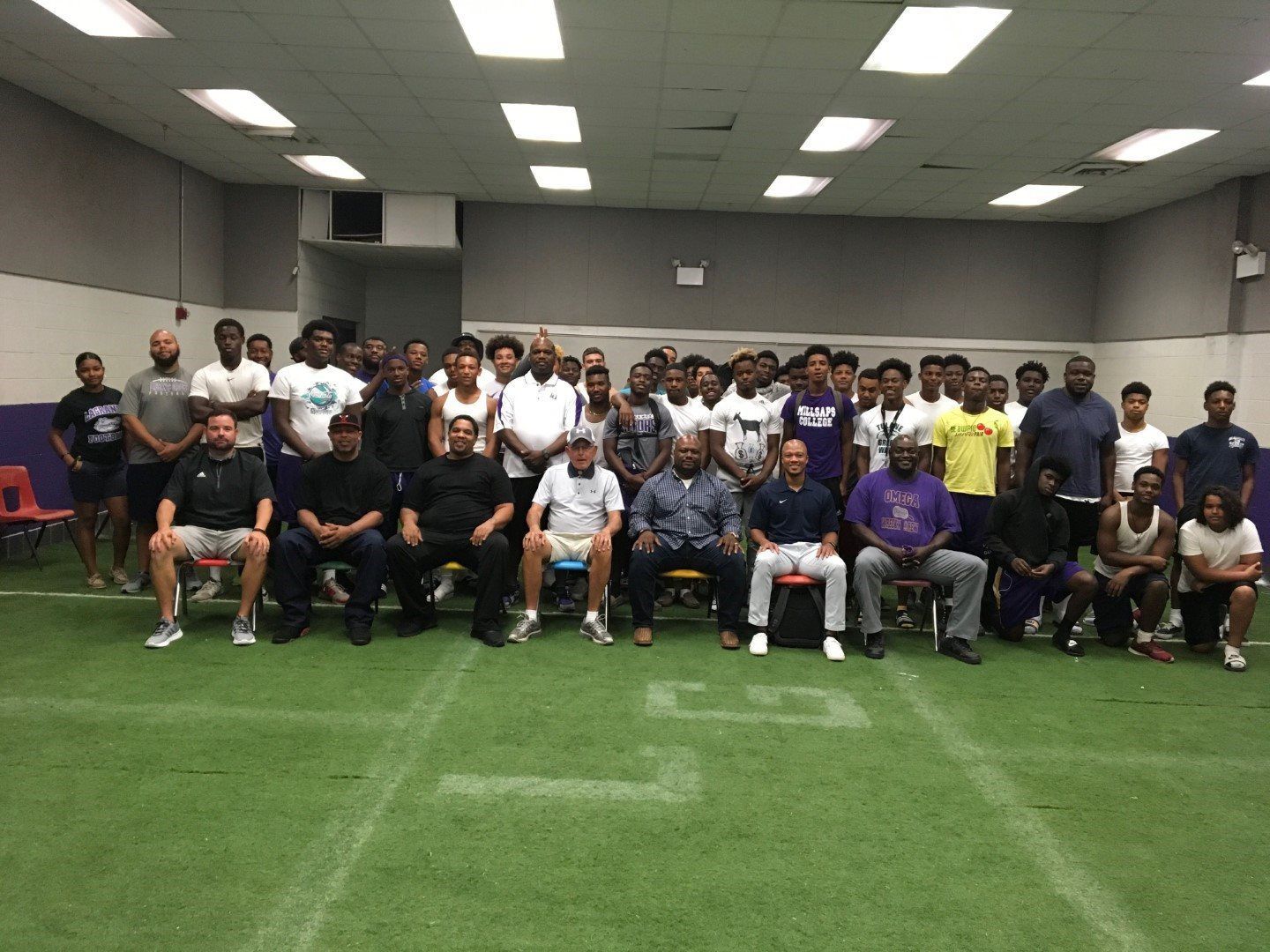 A group of people are posing for a picture in a gym.