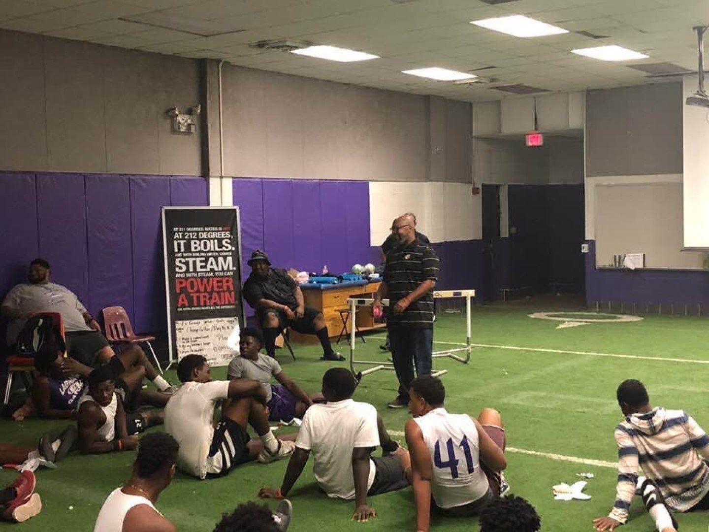 A group of people are sitting on the floor in a room.