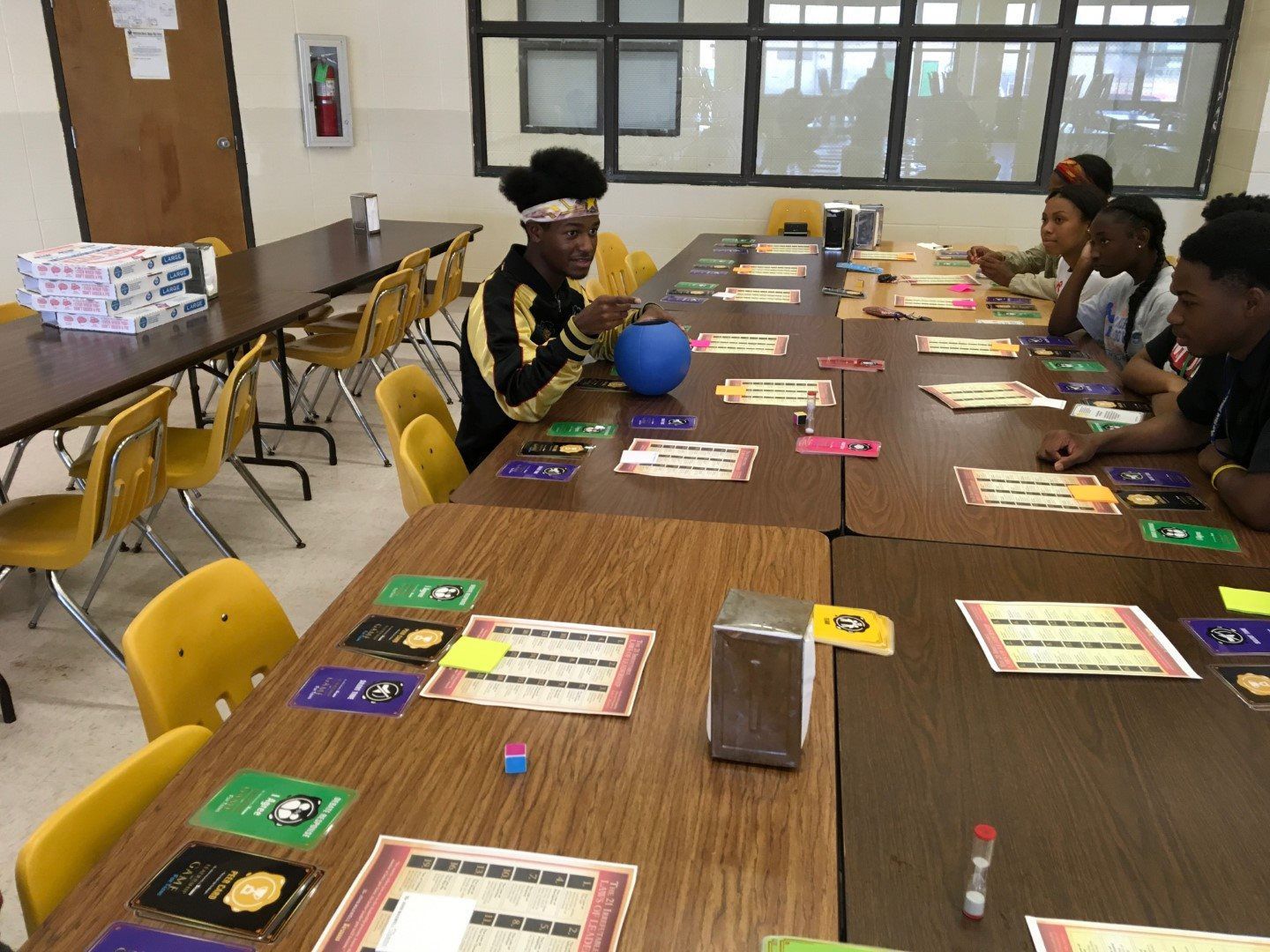 A group of people are sitting at tables in a room playing a game.