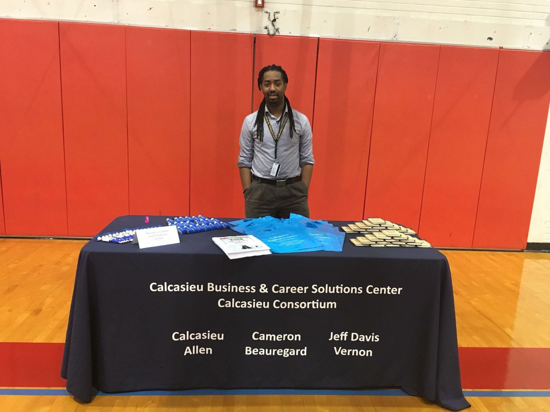 A man is standing in front of a table with a blue table cloth