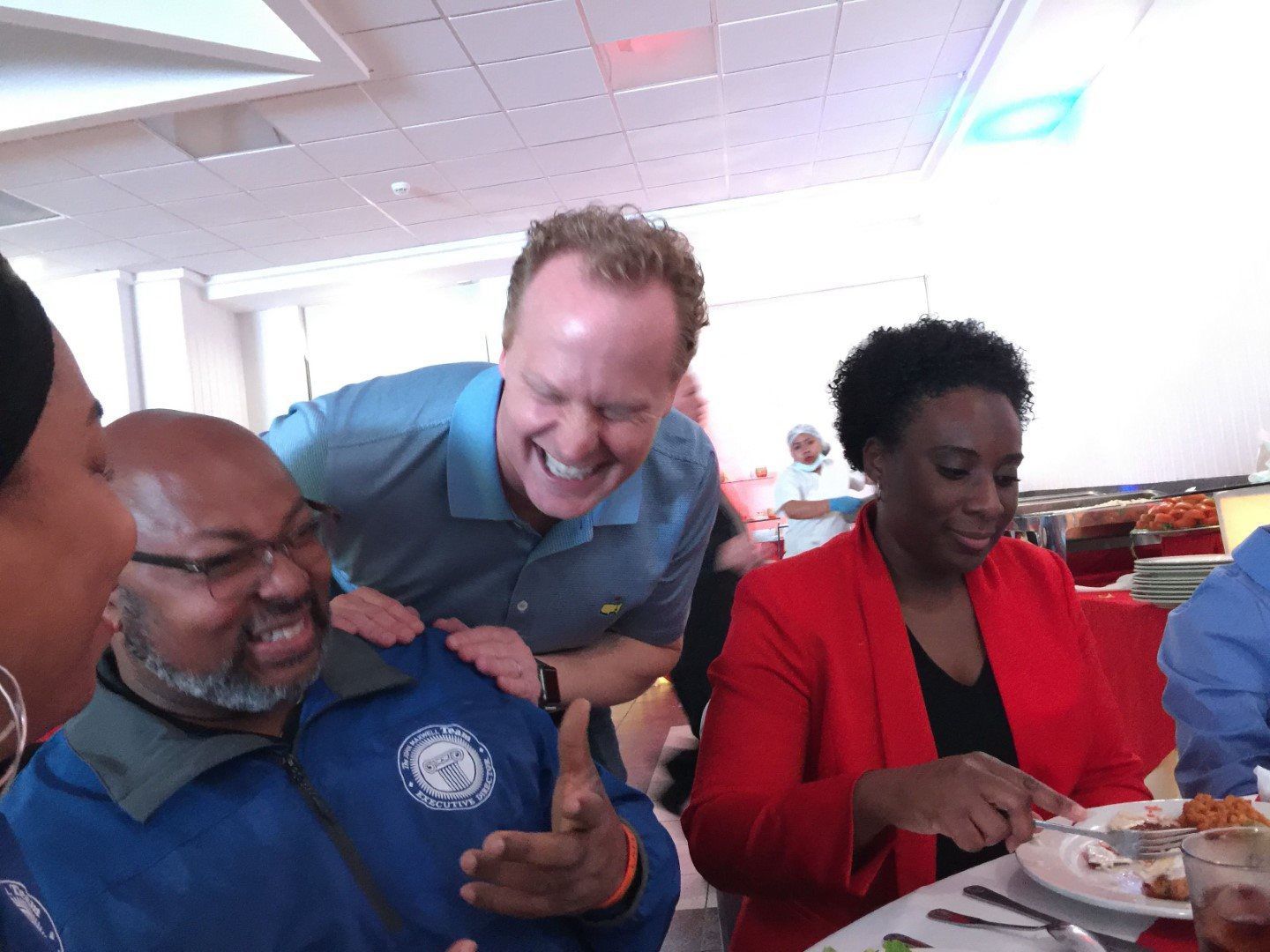 A group of people are sitting at a table and laughing