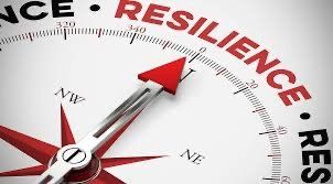 A compass with a red arrow pointing to the word resilience.