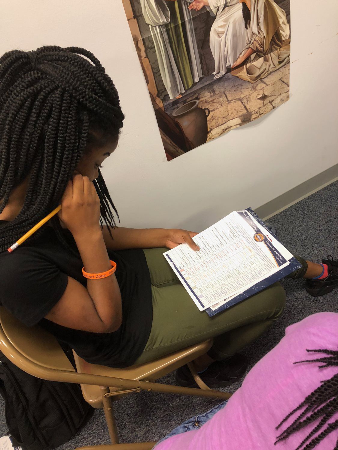 A woman is sitting in a chair reading a book