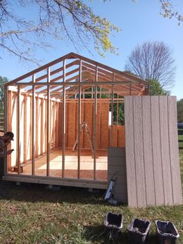 A man is standing in front of a building under construction.