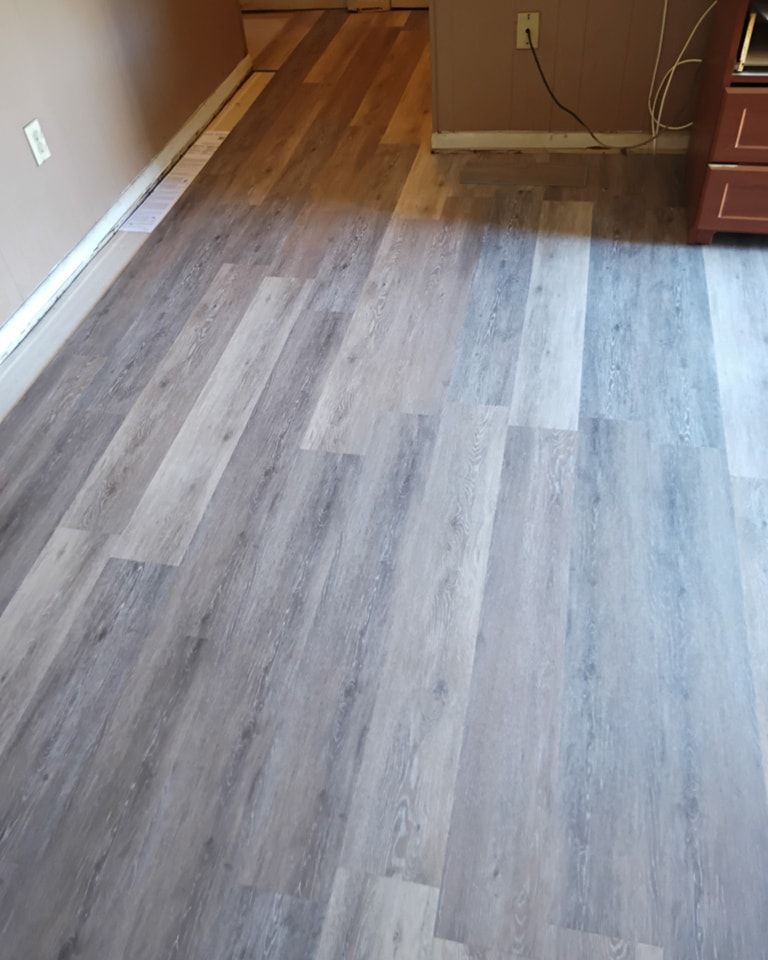 A living room with hardwood floors and a desk.