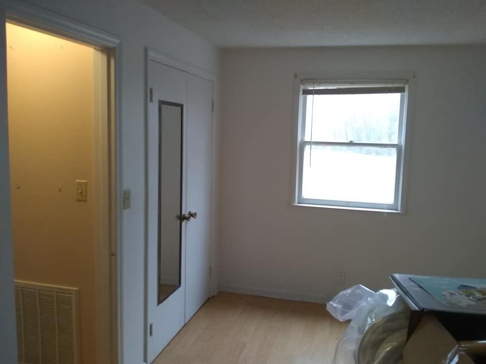 An empty room with a window and a door.