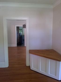 An empty room with a wooden bench in the corner