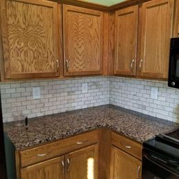A kitchen with wooden cabinets and granite counter tops.