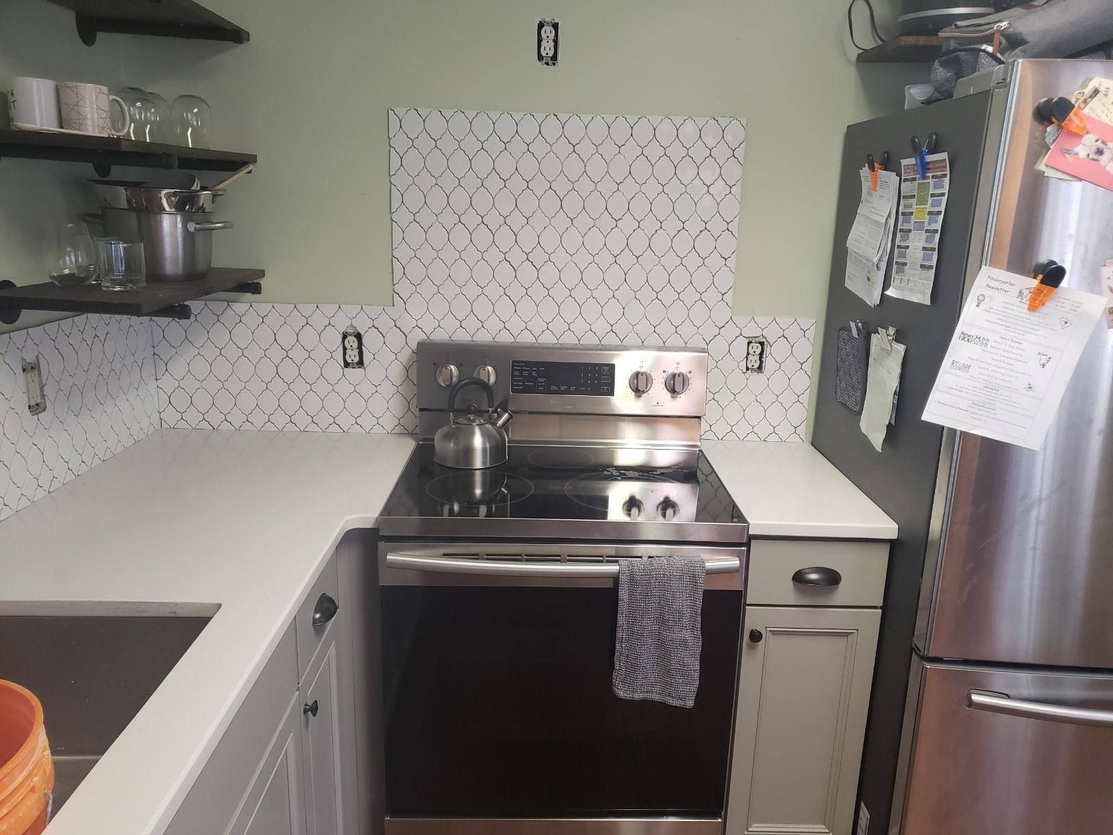 A kitchen with a stove top oven and a refrigerator