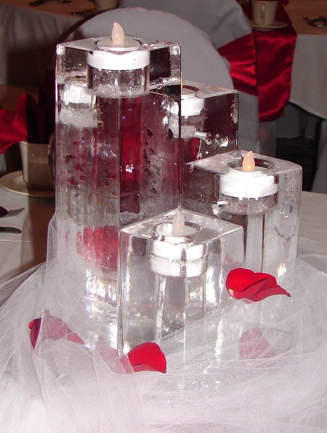 Ice cubes with candles inside of them on a table