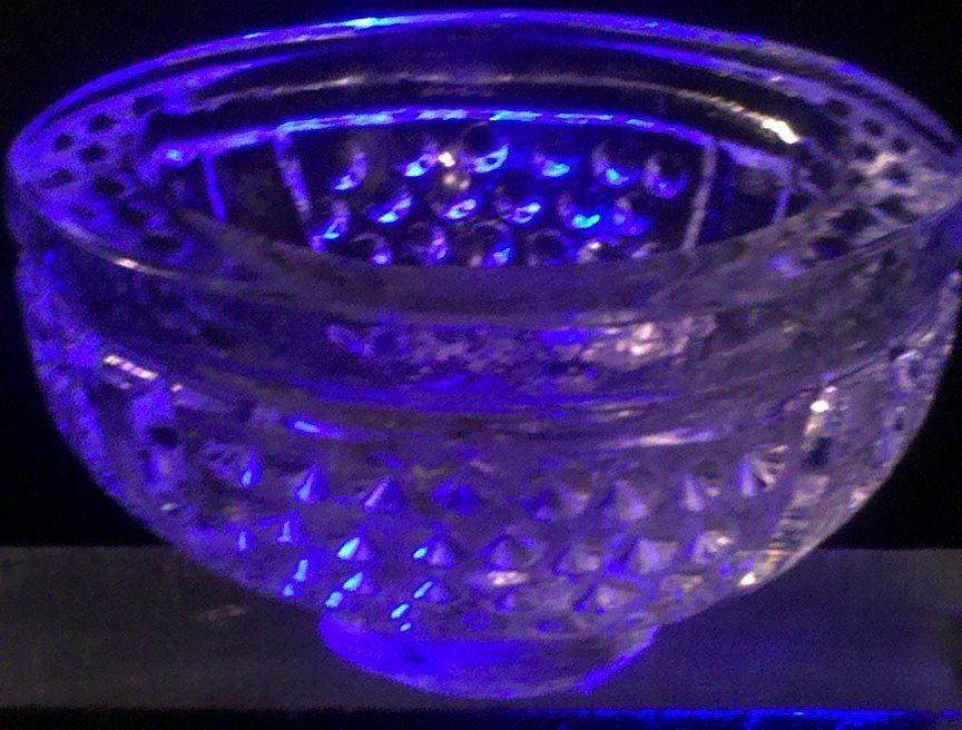 A clear glass bowl is lit up with a blue light.