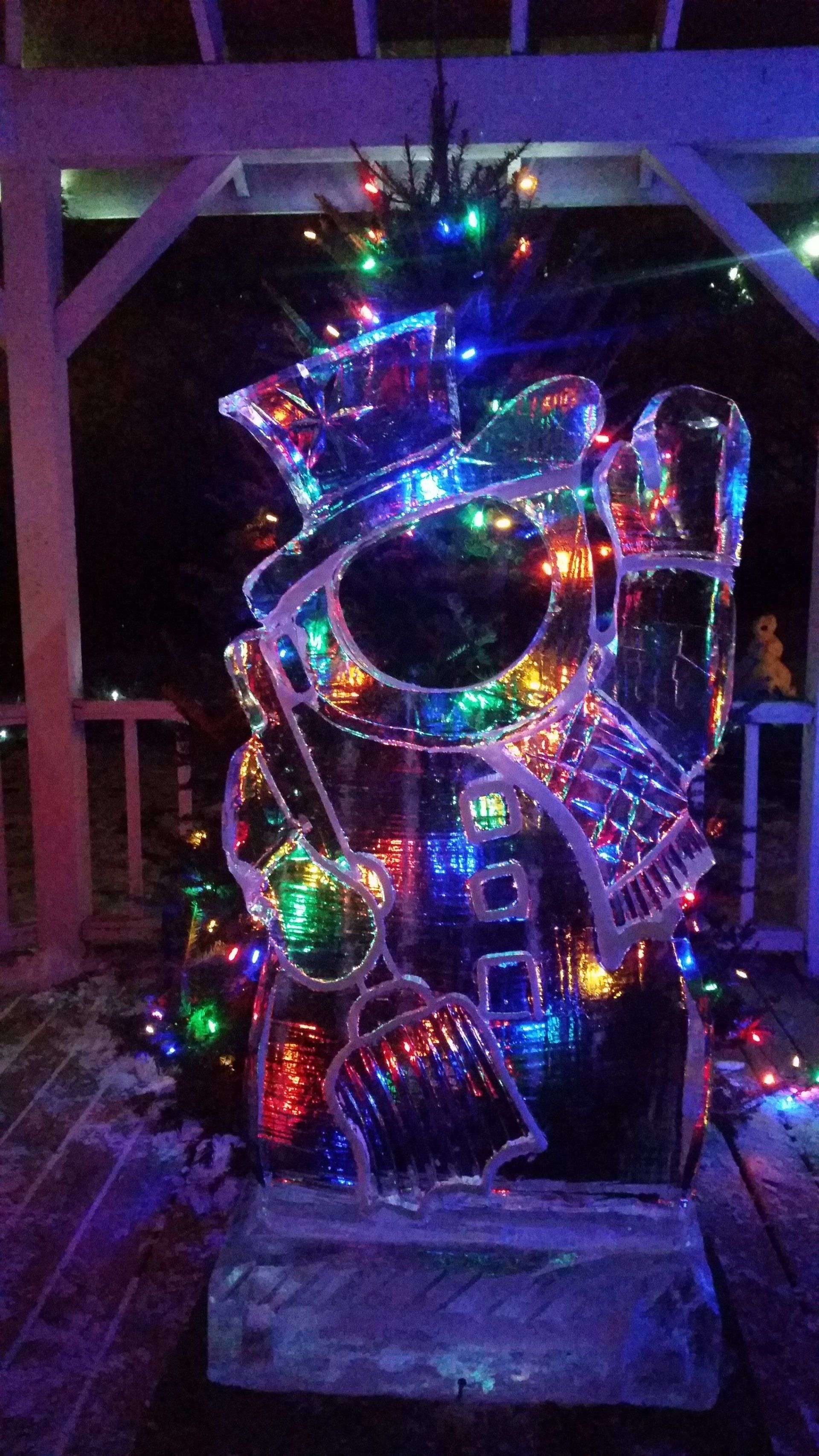 A christmas tree made out of ice and decorated with christmas lights.