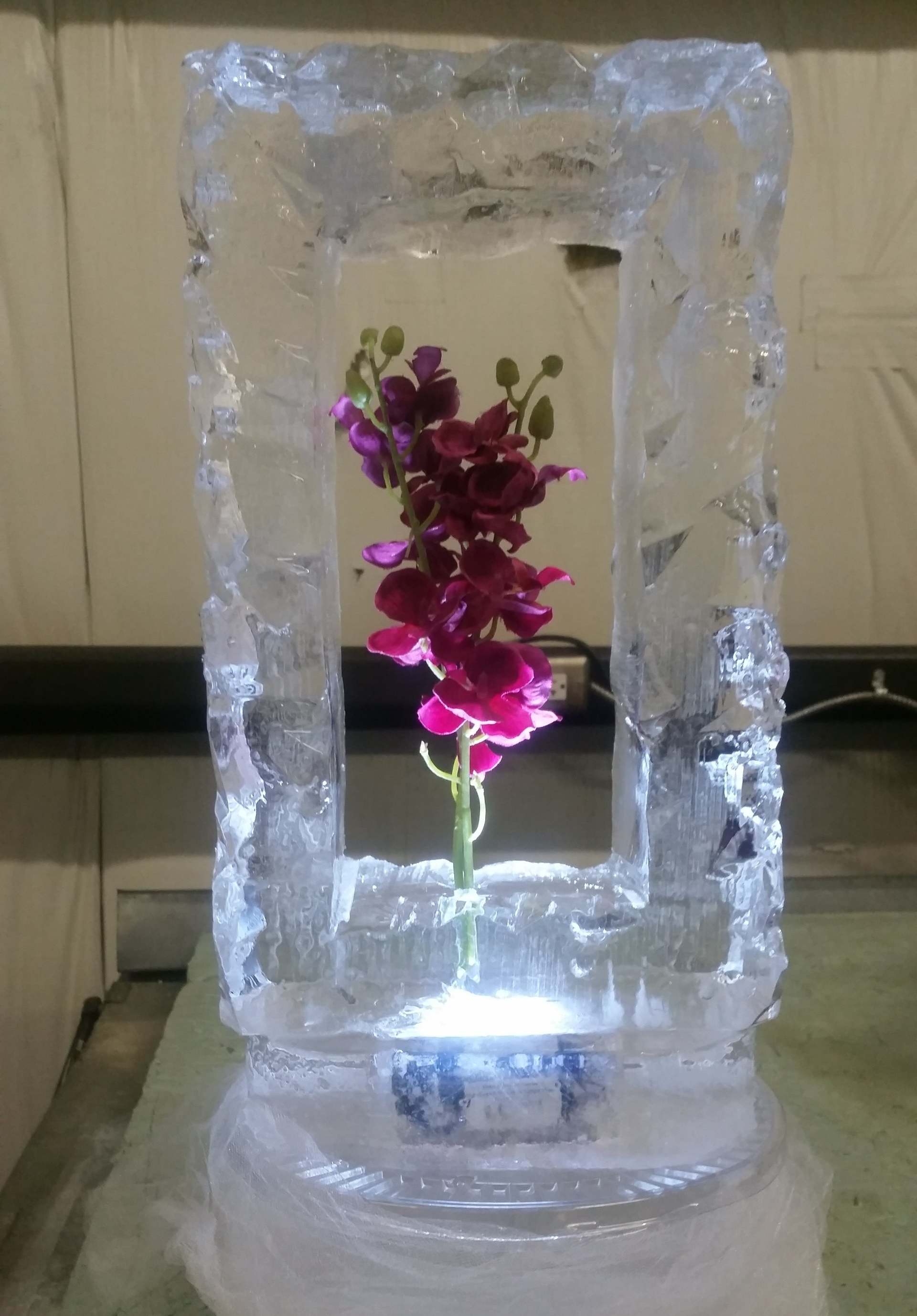 An ice sculpture with a purple flower inside of it