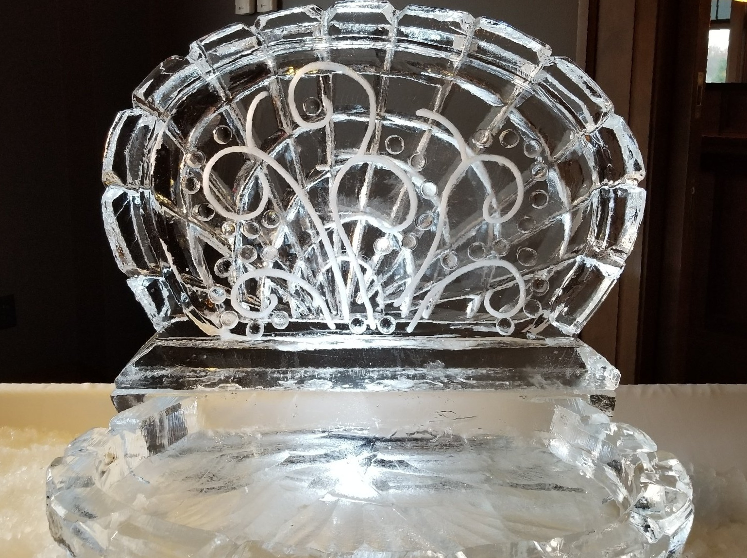 A clear ice sculpture of a chair is sitting on a table.