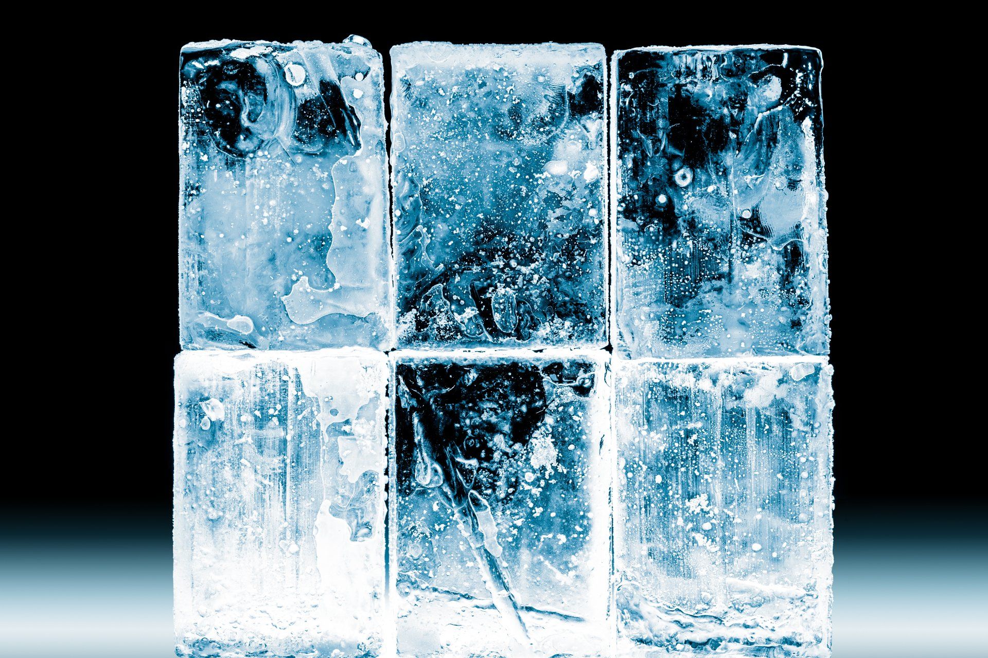 Six ice cubes are stacked on top of each other on a table.