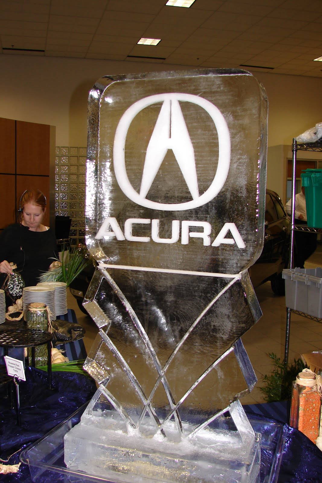 A large ice sculpture of the acura logo is sitting on a table.
